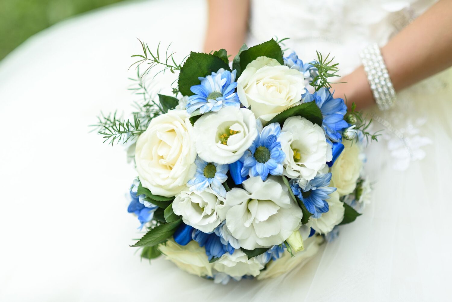 A beautiful bouquet of white roses and blue flowers. Wedding flowers.