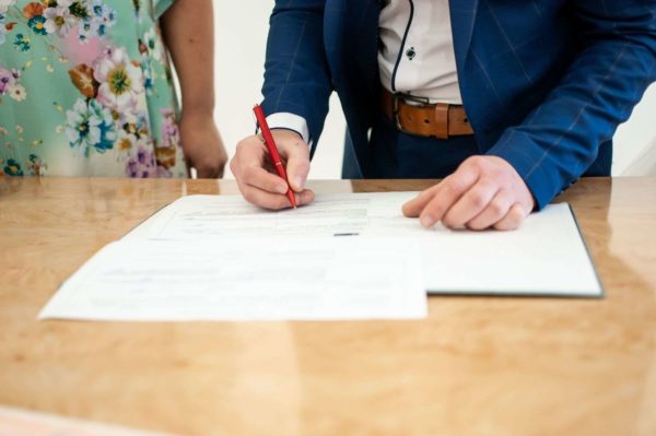 Man signing wedding certificate