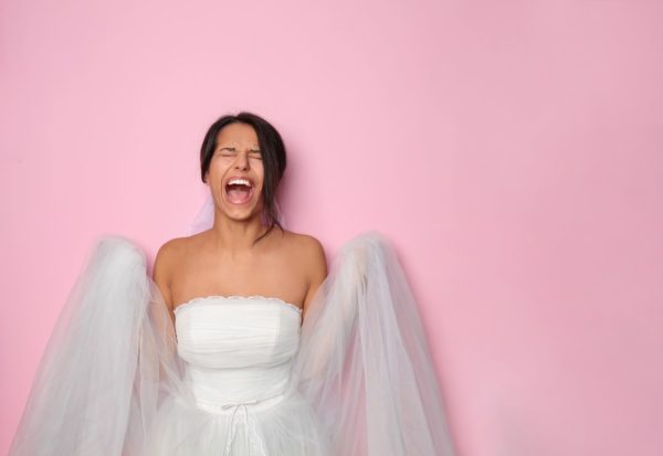 A woman in a white dress with wings, laughing. She appears joyful.