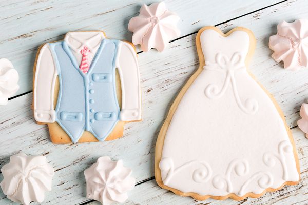 Decorative wedding cookies on a wooden surface, A wedding dress and tuxedo made of cookies