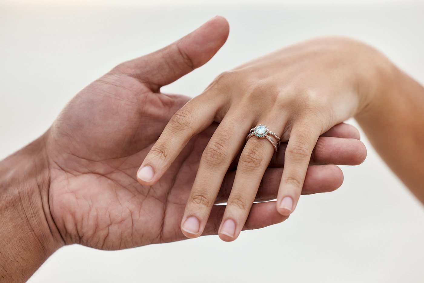 Two hands touching. A wedding ring is visible.