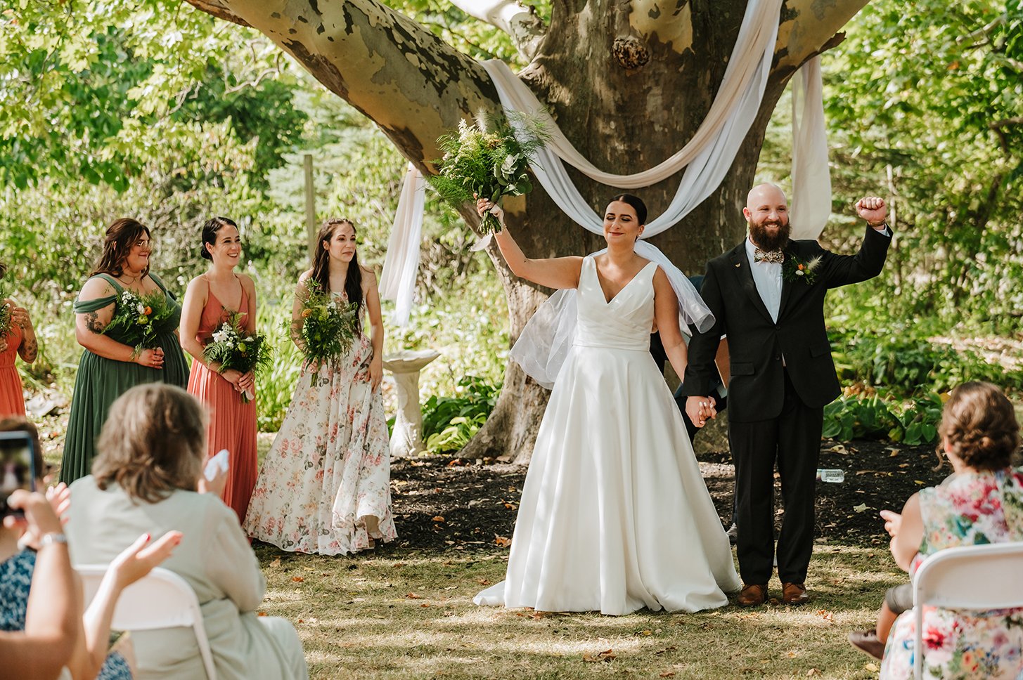 Bride and groom celebrating with bridesmaids around. Happy wedding day