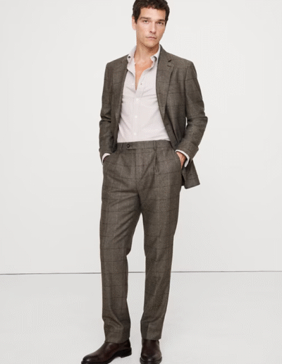 A man in a floral suit stands with an umbrella.