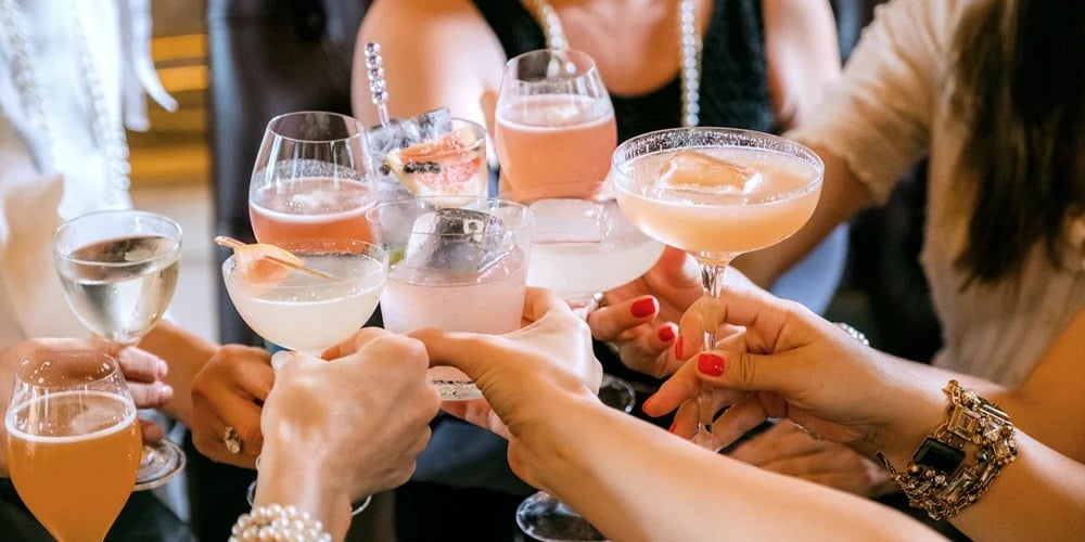 People cheering with wine glasses. Group of friends celebrating.